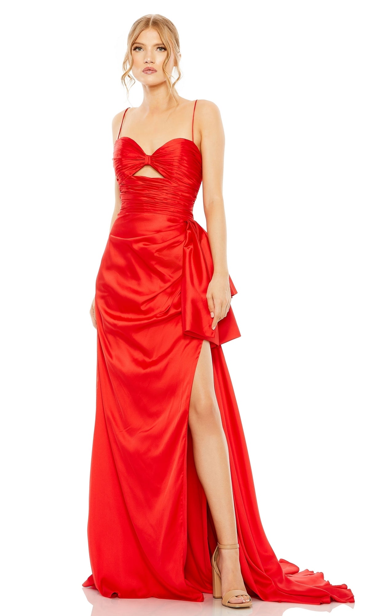 A woman wears the Long Formal Dress 68450 by Mac Duggal, featuring a bright red, floor-length design with spaghetti straps, side slit, ruched sweetheart bodice, bow detail at the hip, and paired with nude high heels.
